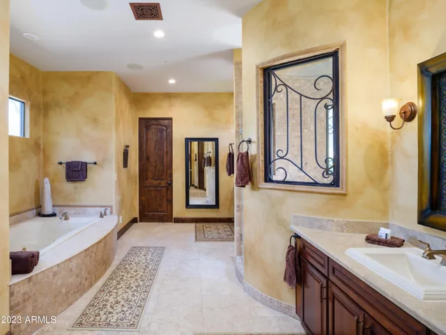 Primary bathroom with dual vanities, large walk in shower, and jetted tub.