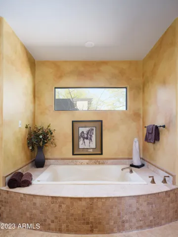 Primary bathroom with dual vanities, large walk in shower, and jetted tub.