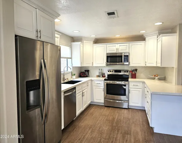 White cabinets, white counter tops, Stainless steel refrigerator with water & ice in the door