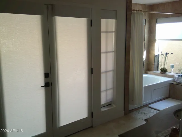 There is a double door access to a private enclosed garden area off the primary bathroom