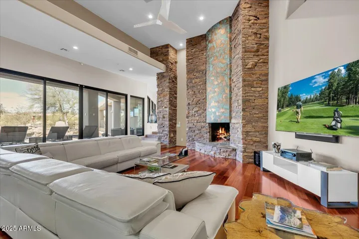Experience the heart of the home in this stunning great room, where rich, warm wood floors set the stage for elegance and comfort. Anchored by a soaring copper fireplace, this space exudes character and warmth, offering the perfect blend of modern luxury and inviting charm.