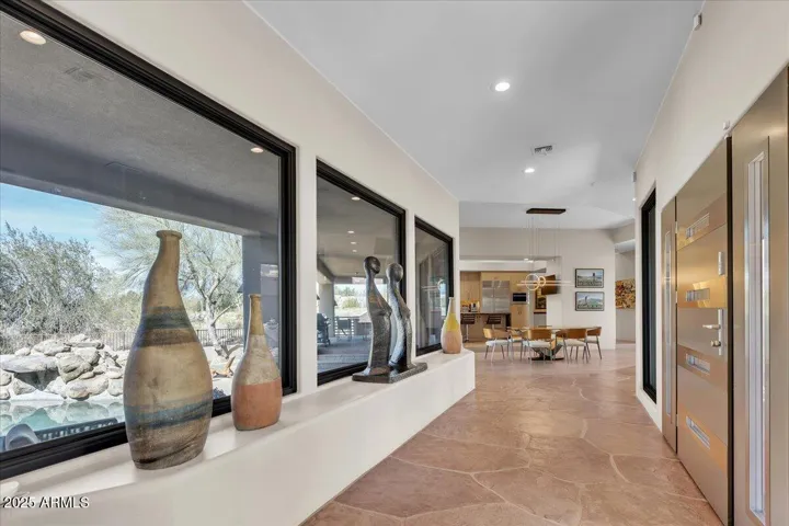 Step into a breathtaking foyer lined with walls of glass, flooding the space with natural light and offering seamless indoor-outdoor connectivity. This striking entrance creates an unforgettable first impression, blending modern sophistication with an airy, open ambiance.