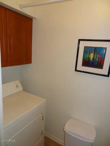 Full size dryer in laundry room inside of condo