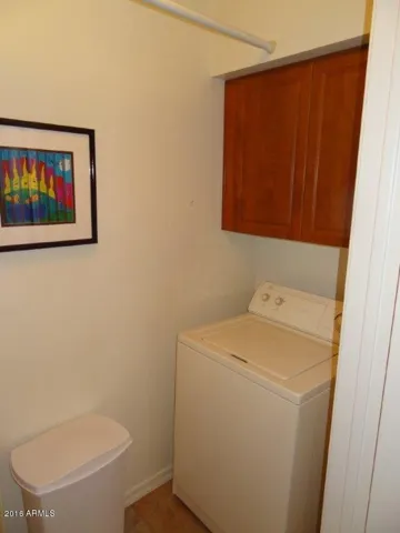 Full size washer in laundry room inside of condo