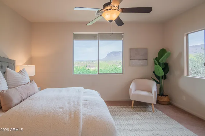 The primary bedroom suite is located downstairs and offers picturesque views of the Superstition Mountains.