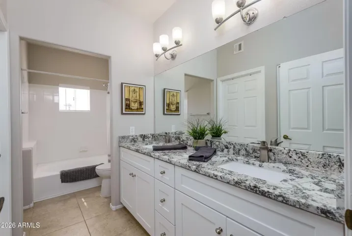 Dual sinks, granite countertops, modern fixtures, private toilet & shower room.