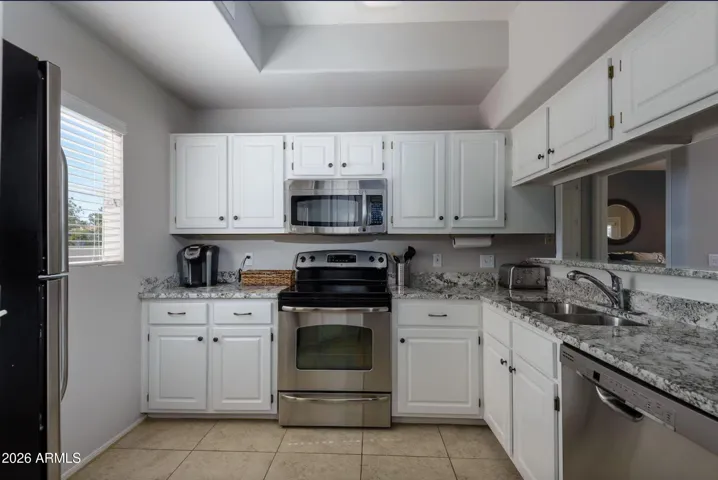 Granite countertops, modern white cabinetry, & stainless steel appliances are just a few of the perks in this fully stocked kitchen!
