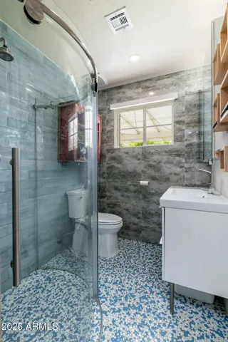 Pass through the closet into this whimsical and smartly designed bathroom