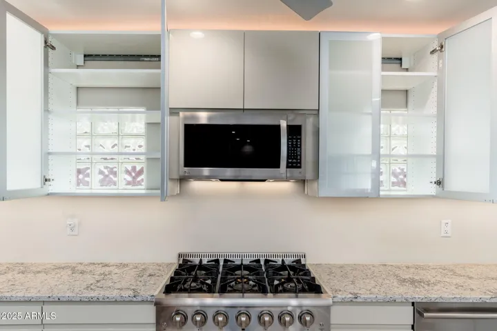 Cabinet backs were removed to allow the original glass block windows to filter natural light. A perfect detail!