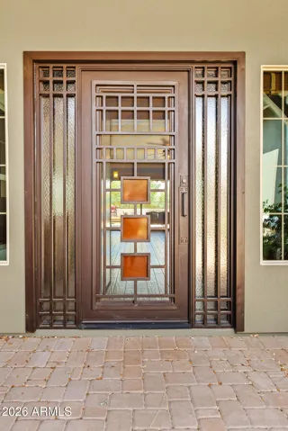 Make a statement with this elegant iron front door featuring geometric glass panels. This secure and stylish entry sets the tone for the craftsmanship found throughout the Phoenix home.
