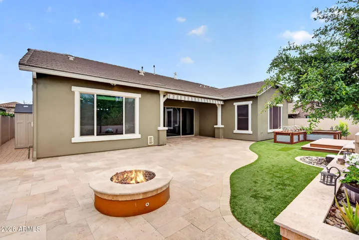 From lush artificial turf to custom paver work, this backyard is made for entertaining. Featuring a firepit, patio seating, and raised planters, this outdoor oasis complements the home’s beautiful design.