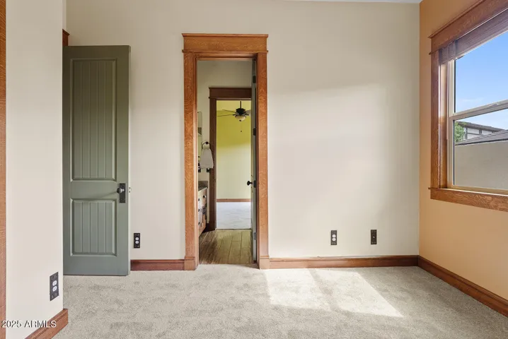 This light-filled bedroom offers charming wood casings, soft carpeting, and convenient access to the Jack & Jill bathroom. Ideal for kids, guests, or a flexible office setup in this Phoenix gem.