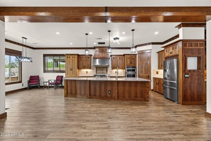 The gourmet kitchen includes a Jenn-Air gas range, double ovens, and a granite-topped island perfect for cooking, serving, or gathering. Beautiful custom cabinetry completes the scene.