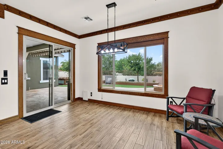 Sunlight streams into this dining area through large windows showcasing the professionally landscaped backyard. A perfect spot to enjoy meals with Arizona sunshine year-round.