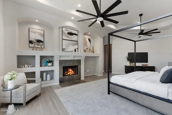 Master bedroom with gas fireplace and two ceiling fans.