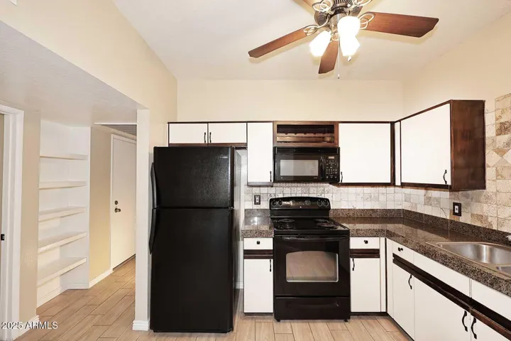 Charming kitchen includes lots of cabinets & built-in wine rack, black appliances & granite counters!