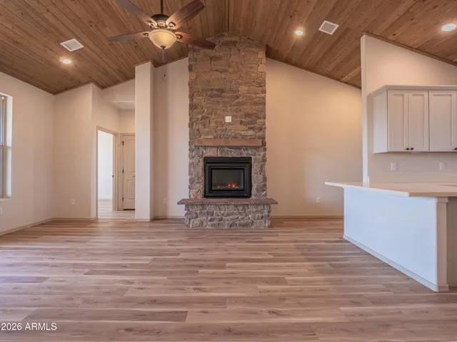 Great room with tongue and groove ceiling and stone fireplace