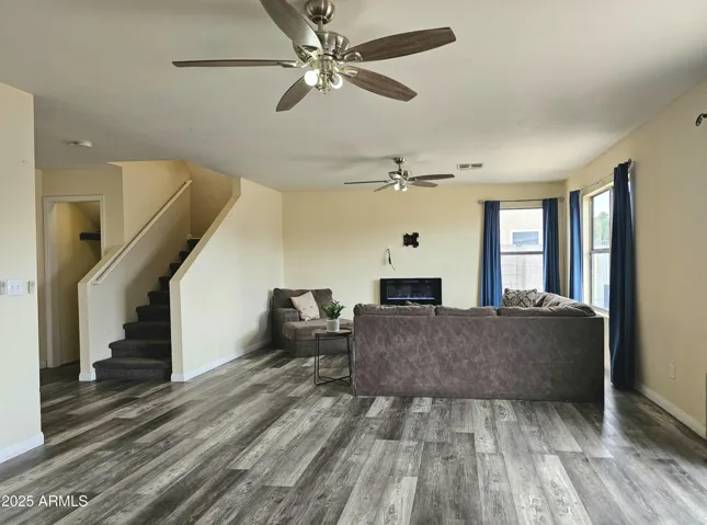 Open living area with stylish flooring and ceiling fan