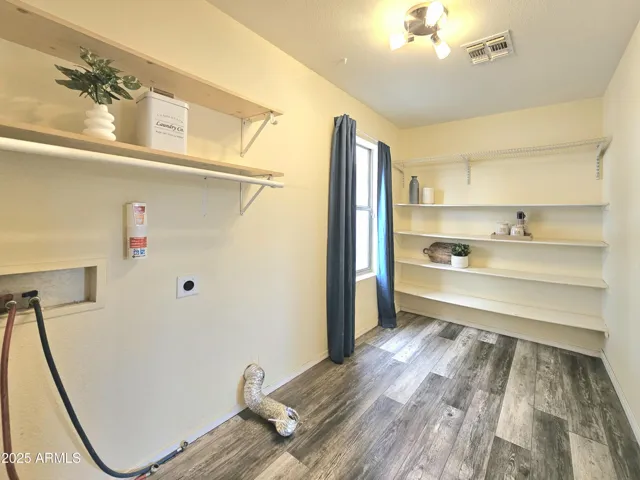 Combo laundry and storage room with window lighting.