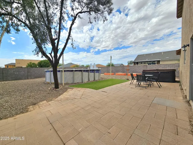 Private backyard retreat with hot tub, above-ground pool, and sitting area.