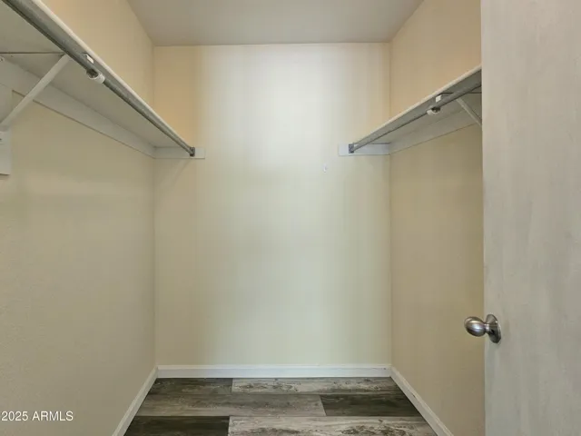 Primary walk-in closet with dual hanging racks.