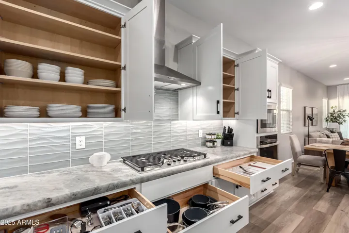 Stocked kitchen with plates, bowls, cups, utensils, coffee bar, small appliances, and cooking & backing essentials