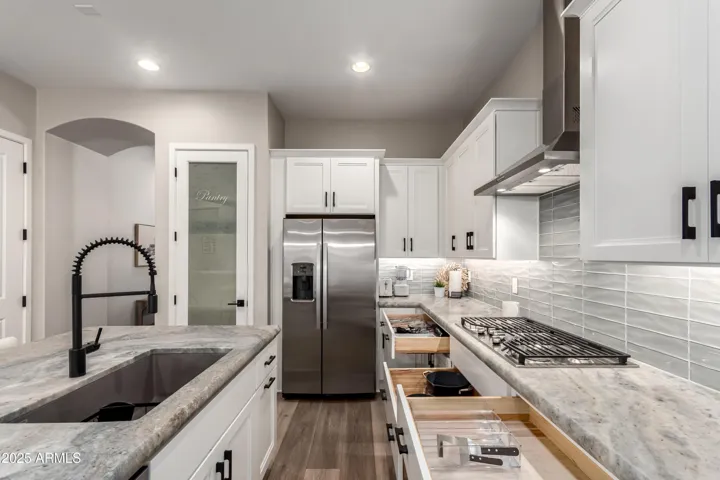 Stocked kitchen with plates, bowls, cups, utensils, coffee bar, small appliances, and cooking & backing essentials
