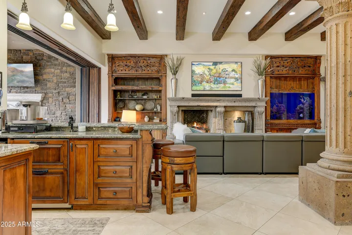 Entertain with ease in this luxury living space featuring a fully stocked custom bar, granite counters, and carved cabinetry—designed to impress and inspire gatherings.