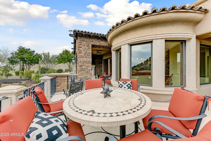 This upper-level balcony offers an intimate outdoor dining experience with charming architectural detailing, curved window lines, and resort-style seating. Located just off the kitchen, this space blends luxury living with indoor-outdoor functionality—ideal for entertaining in Scottsdale's mild climate.
