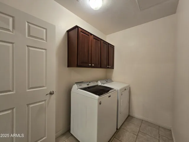 Laundry room off garage includes washer, dryer, cabinets