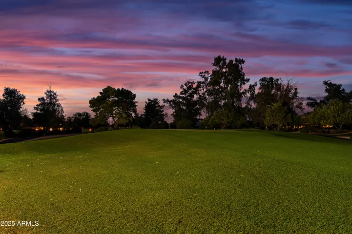 View from huge master bedroom picture window with golf green lit up at night with the home's flood light system.