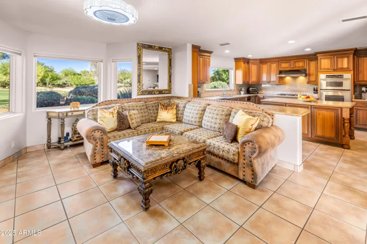 Enter through courtyard's French doors into a large living room with 4 huge picture windows, Ralph Lauren mirrors in front of the spacious kitchen's breakfast bar and island overlooking golf green.