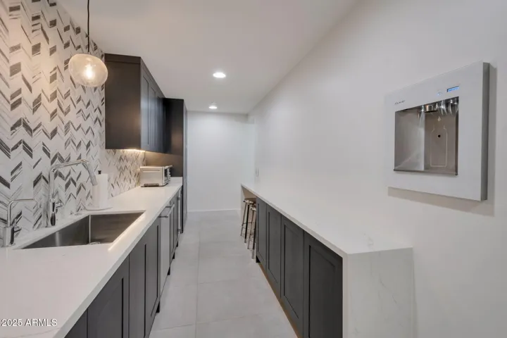 Butler's kitchen view - includes ice maker, extra sink and dishwasher, beverage fridge, and water bottle fill station.