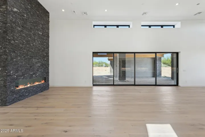 Great Room with expansive sliding door and floor to ceiling custom fireplace