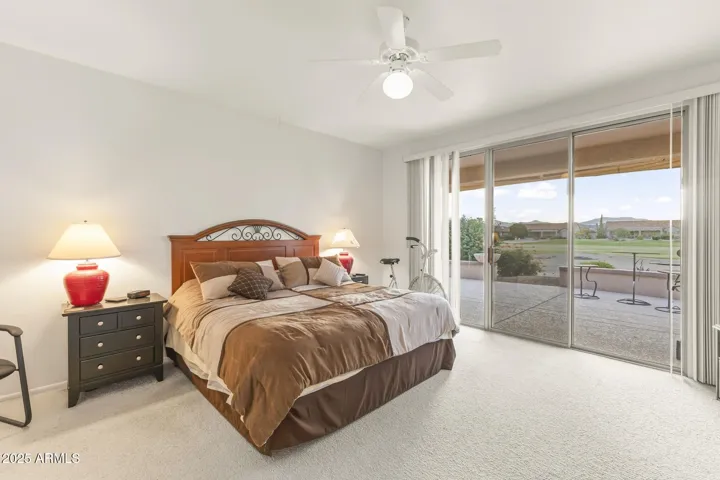 Spacious main bedroom with sliding doors to the patio and stunning golf course views—perfect for relaxation and morning sunshine.