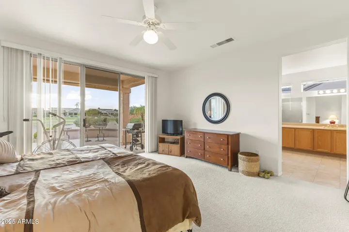 Inviting main suite overlooking the lush golf course with direct patio access and natural light that enhances the room’s serene atmosphere.