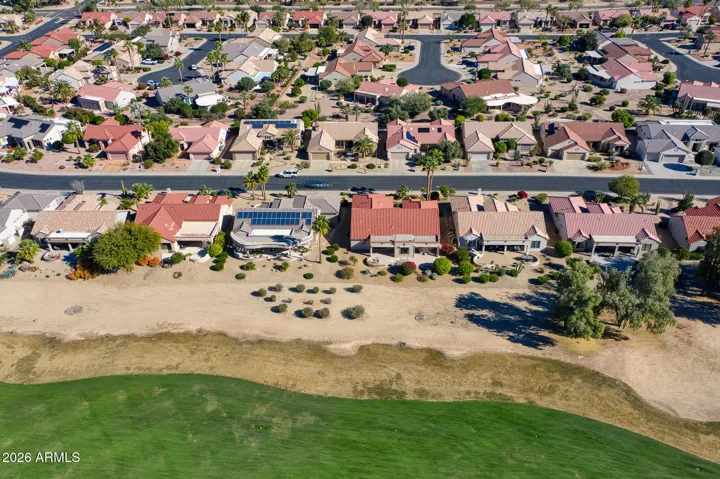 Aerial view showcases this beautiful home backing onto the Granite Falls South Golf Course in Surprise. The desert landscaping, red tile roof, and open fairway views highlight its prime location and outdoor lifestyle appeal.
