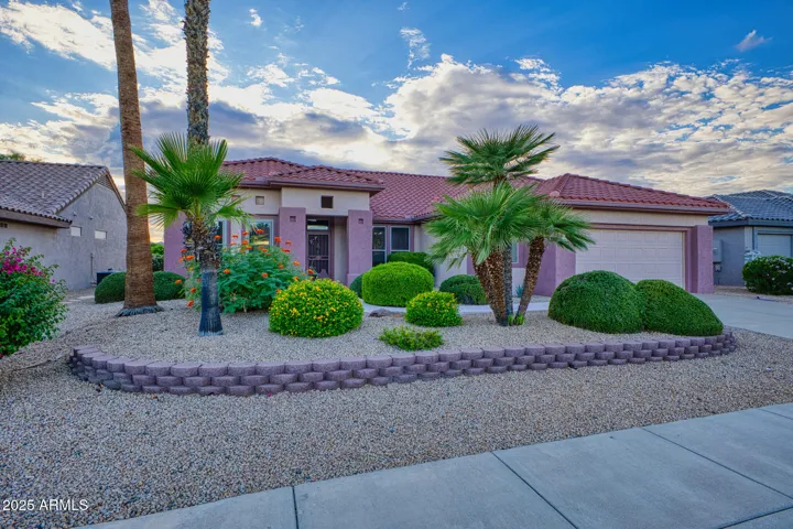 A welcoming front entry framed by desert plants, architectural columns, and vibrant greenery—perfectly blending modern style with Arizona’s natural beauty.