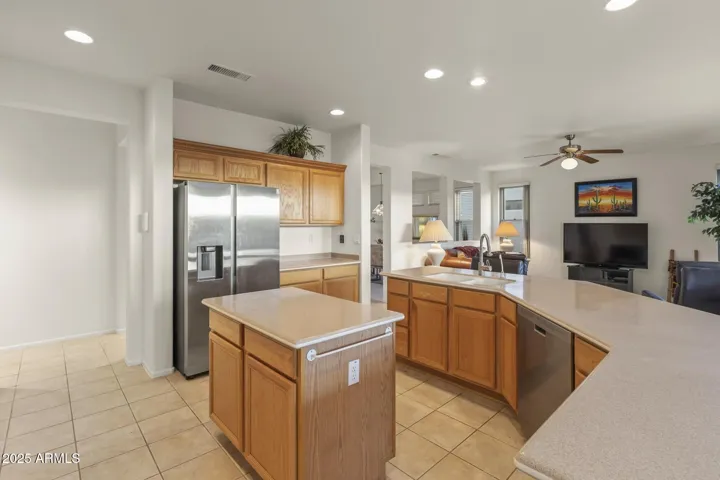Functional kitchen boasting a stainless refrigerator, expansive counters, and island prep space for a perfect balance of form and function.