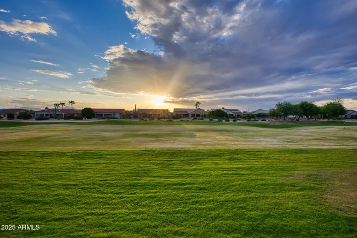Gorgeous twilight captures this home’s stunning architecture and landscaped yard. The warm light enhances the beauty of the fairway and mountain views beyond, emphasizing its idyllic setting.