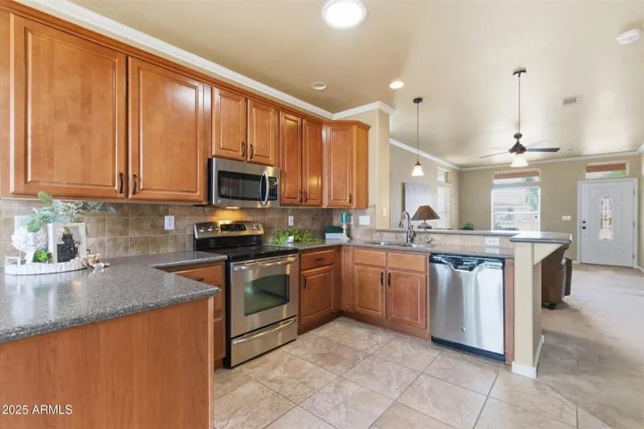 GE stainless steel appliances, breakfast bar seating, and recessed lighting create a perfect blend of function and style.