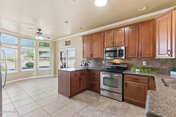 Skylights and large windows fill the kitchen with sunlight, highlighting the sleek finishes and open layout.