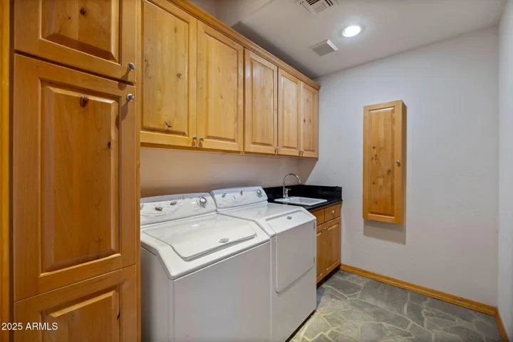 Laundry Room with built in cupboards and ironing board.