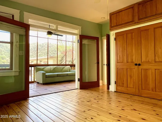 Primary bedroom with French doors to screened-in porch/balcony.