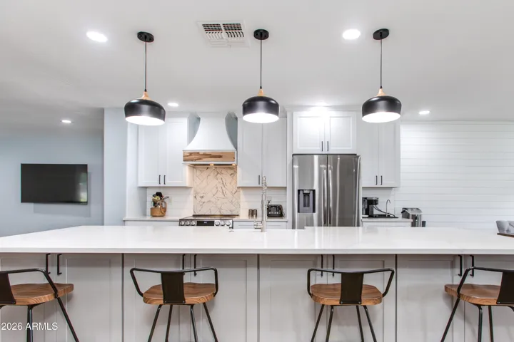 This designer kitchen truly steals the show! Featuring crisp white shaker cabinetry, sleek quartz countertops, stainless steel appliances, and a stunning tile backsplash, this space blends modern style with everyday functionality.