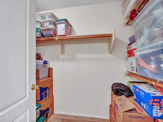 Cozy bedroom offering soft carpeting, ceiling fan, and nearby closet space, ideal for guests or a home office setup.