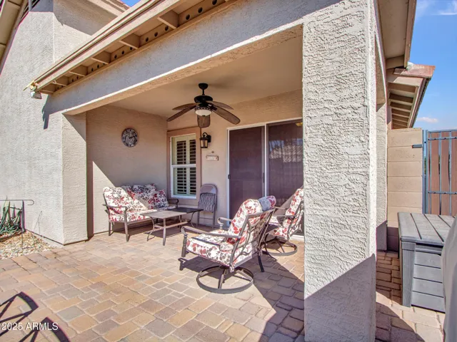 Covered patio with seating area and sliding glass doors, extending the living space outdoors for seamless indoor-outdoor living.