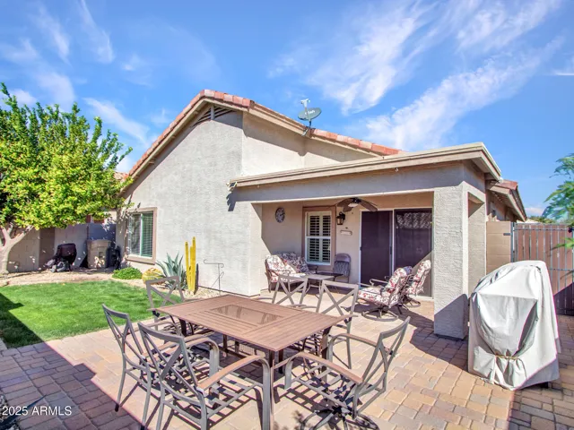 Well-maintained backyard combining lush grass, paver walkways, and desert landscaping for low-maintenance outdoor living.