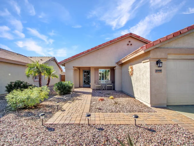 Paver walkway guides you to the covered entry, framed by desert landscaping. Designed for easy living and great curb appeal in Buckeye.