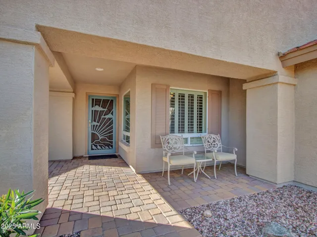Covered front patio creates a shaded outdoor sitting area, adding charm and functionality. A perfect welcome into this Buckeye residence.